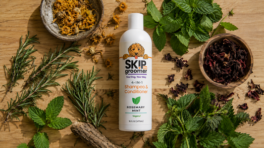 Skip The Groomer 4-in-1 Rosemary Mint Shampoo surrounded by its actual herbal ingredients — rosemary, peppermint, calendula, hibiscus, nettle, and burdock root — honest formulation.